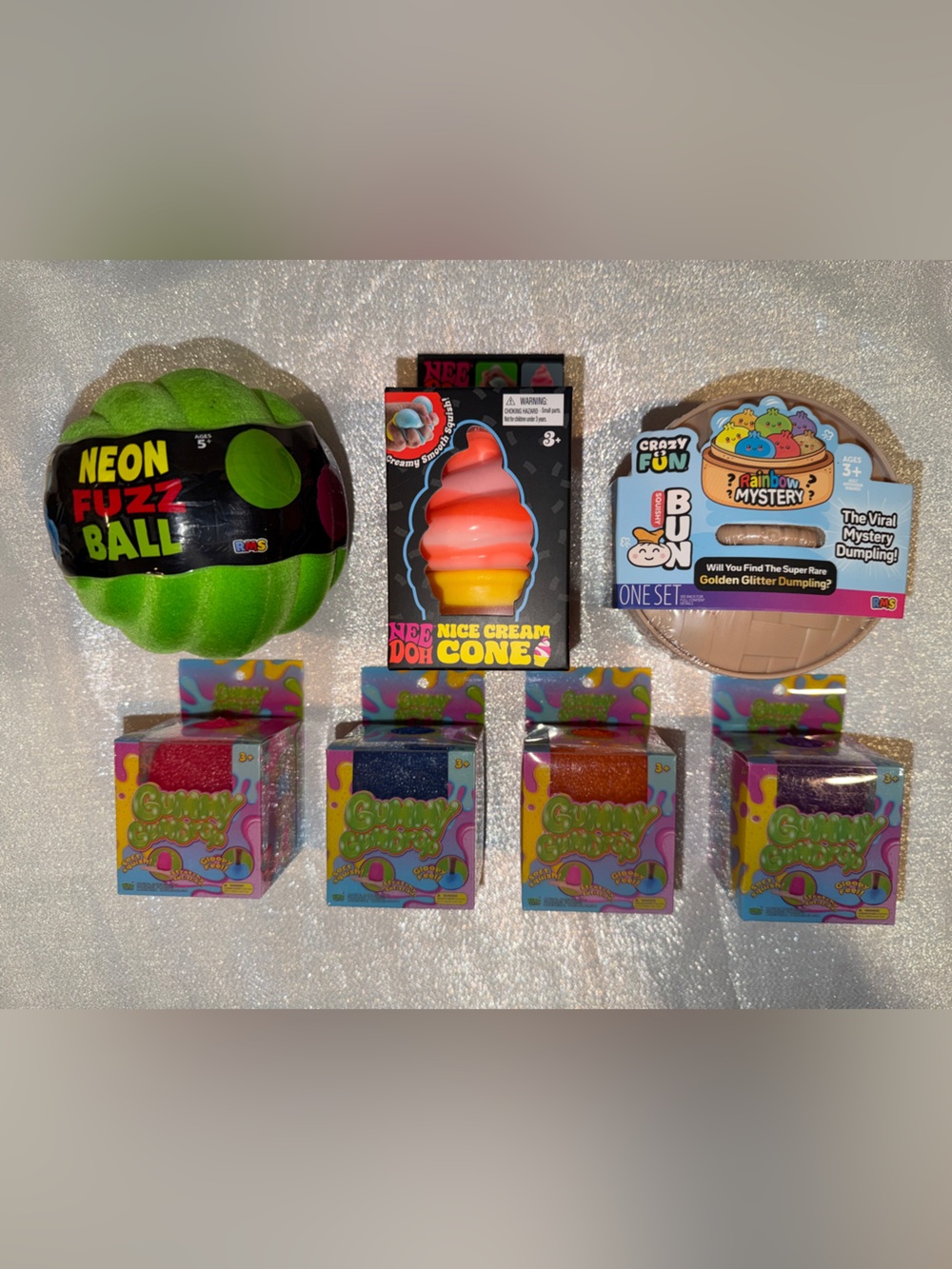 1 NeeDoh Ice Cream, 1 Glitter Mystery Dumpling, 1 Neon Fuzz Ball & 4 Gummy Drops